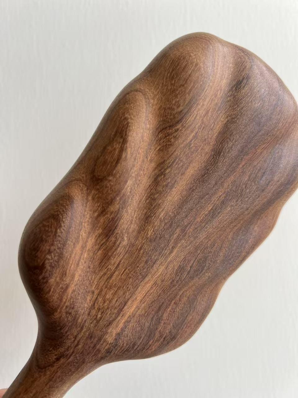 Backside detail of Joy Garden Hair Growth Brush – smooth golden rosewood finish for premium quality look