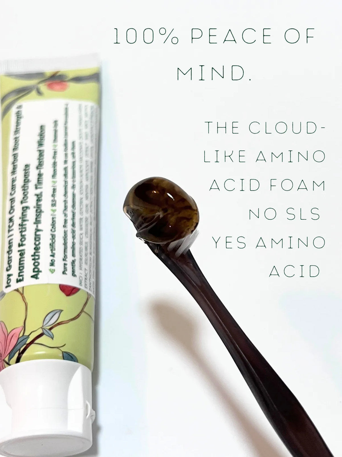 Dark amber botanical toothpaste on toothbrush featuring SLS-free gentle amino acid cleanser
