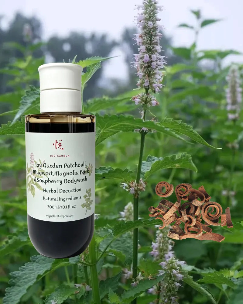Joy Garden Patchouli Mugwort Magnolia Bark and Soapberry Body Wash bottle with flowering herbs and natural bark curls